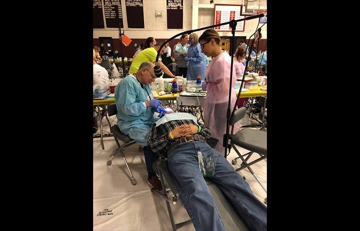 Dentist offering dental care at community event