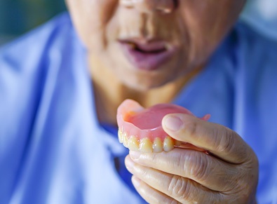 Person holding an upper denture