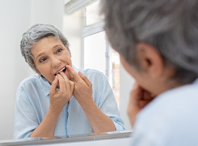 Woman flossing in bathroom