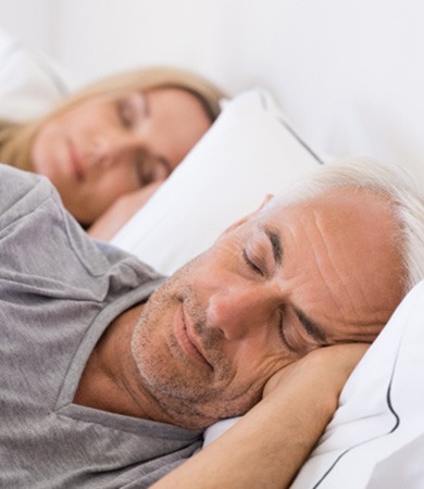 man sleeping in bed with wife