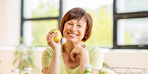 Older woman holding green apple