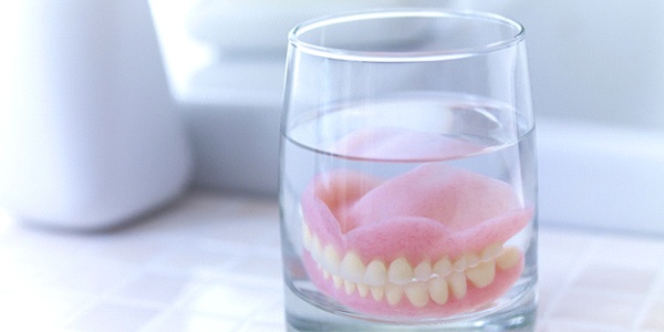 Dentures in Glastonbury soaking in glass on countertop