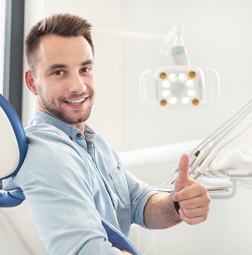 Male dental patient giving a thumbs up