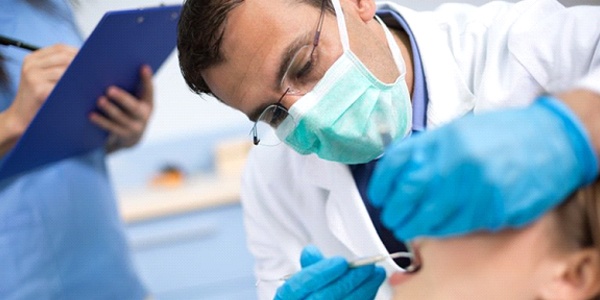 A dentist performing treatment on a patient.
