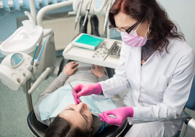 a female emergency dentist performing dental work on a patient
