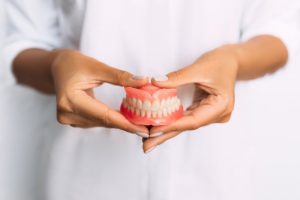 hands holding dentures