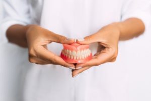 Person holding a clean set of dentures.