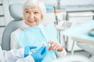 an older patient and their dentist chatting about dentures