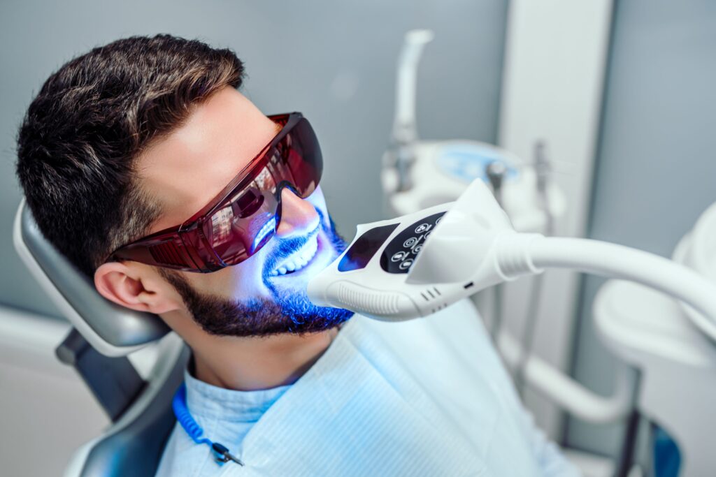 Man in dental chair undergoing teeth whitening procedure