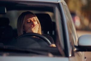 Woman yawning while driving. 