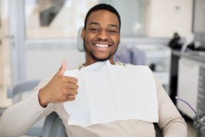 Man smiling and holding thumbs up